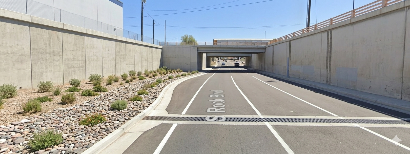Rendered visualization of completed Rock Boulevard Rehabilitation showing new retaining wall, rock and shrubbery landscaping, slotted drains, and UPRR underpass
